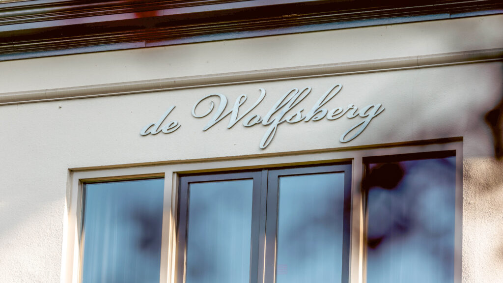 Fassade des Hotels De Wolfsberg mit Namensschild