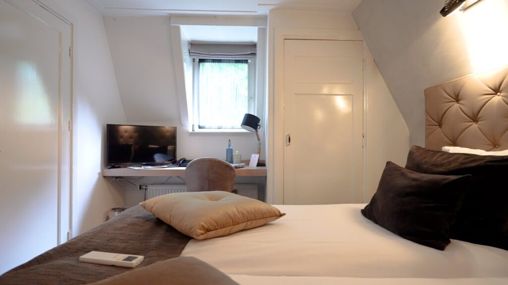 Hotelkamer met bureau en televisie onder de kap in De Wolfsberg