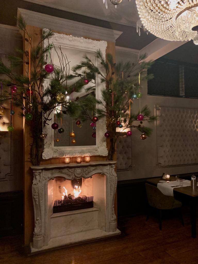 Open haard met kerstgroen in de Wolfszaal
